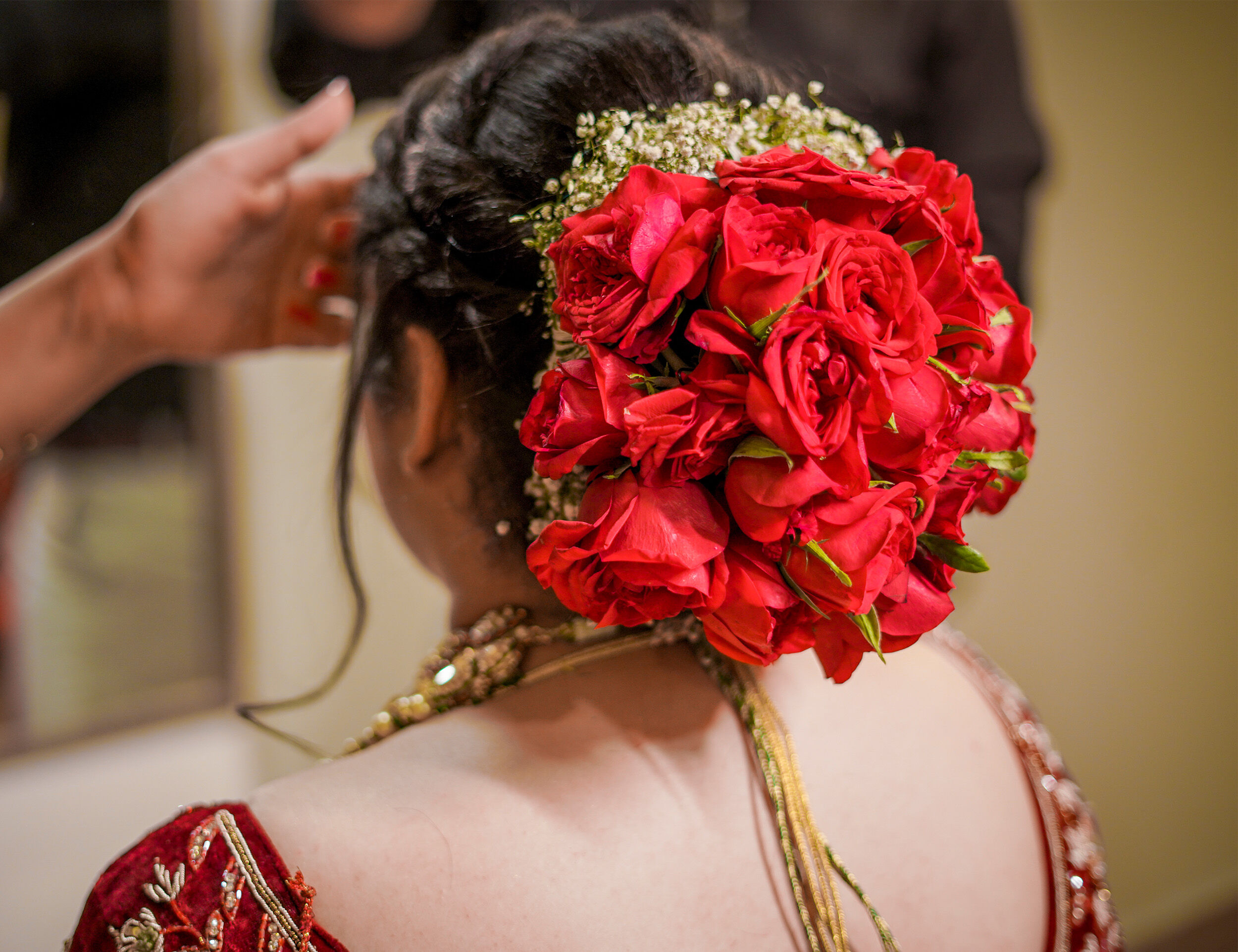 A bride with red roses on her hair 